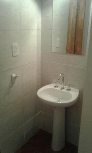 y baño con lavabo blanco y espejo. en Pequeña Villa en San Rafael