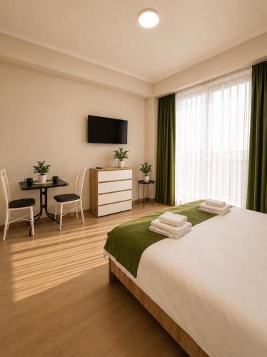 a bedroom with a bed and a table and a television at N4 Alvina Complex in Tsaghkadzor