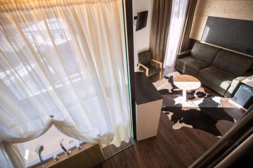 a living room with a couch and a table at Hotel Al Cervo in Tesero