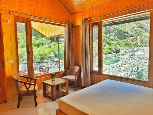 a bedroom with a bed and a window at Riverside Bliss Cottages in Gushaini