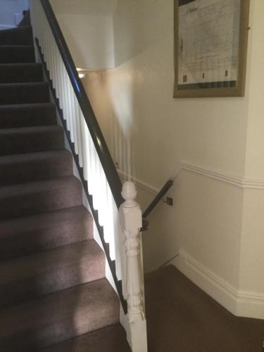 a staircase with white railings and a picture on the wall at The Windsor Carlton in Blackpool
