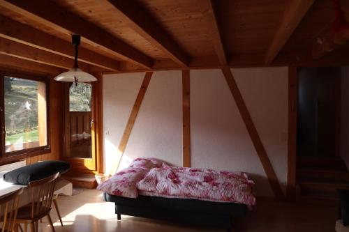 a bedroom with a bed and a table in a room at Stöckli aux Fontaines in Tramelan