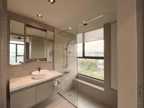 a bathroom with a sink and a glass shower at Expressionz Suites, 300mbps Wifi, near KLCC, IJN by Wodages in Kuala Lumpur