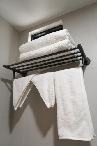 a group of towels on a towel rack in a bathroom at Rasgrand in Rasdhoo
