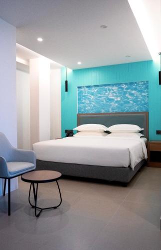 a bedroom with a bed and a table and a chair at Rasgrand in Rasdhoo