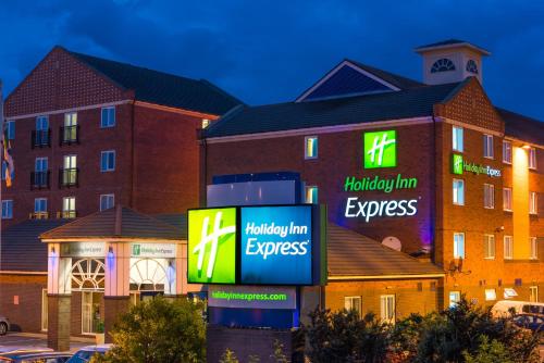 ein Hotel mit Schildern vor einem Gebäude in der Unterkunft Holiday Inn Express Newcastle Gateshead by IHG in Newcastle upon Tyne