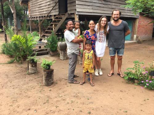 a family posing for a picture in front of a house at Sok Phen Homestay in Siem Reap