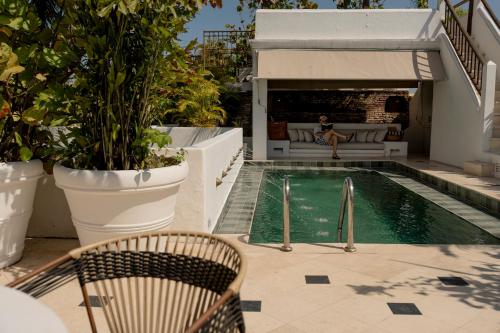 a woman sitting on a chair next to a swimming pool at Amarla Boutique Hotel Cartagena in Cartagena de Indias