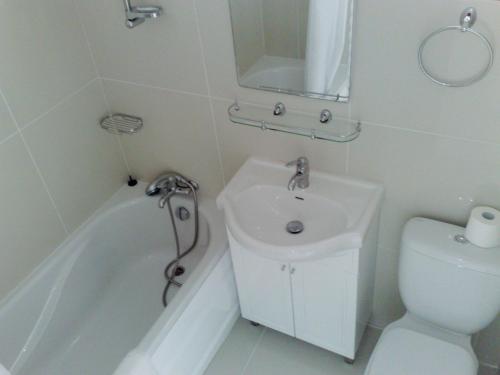 a white bathroom with a sink and a toilet at Hilltop Gardens Hotel Apartments in Paphos City
