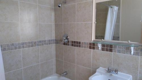 a bathroom with a sink and a mirror at Oasis Motel in Antigonish