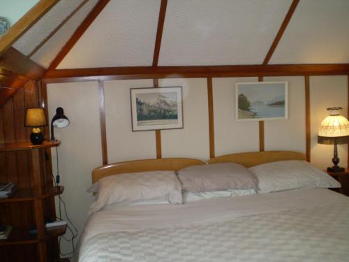 uma cama num quarto com duas fotografias na parede em Federation House em Oamaru