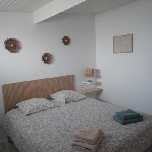 a bedroom with a bed with two towels on it at Chez Isa et JP in Soulac-sur-Mer
