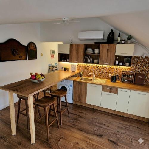 a kitchen with a wooden table and some stools at Wood Nest in Bragadiru