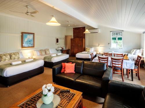 ein Wohnzimmer mit zwei Betten und einer Couch in der Unterkunft Maleny Hotel in Maleny