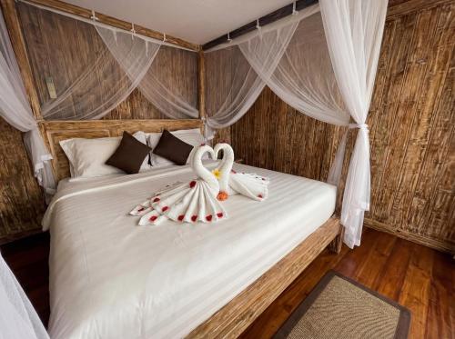 a bedroom with a bed with two swans on it at Villa Wakem Yehpoh in Yehpoh