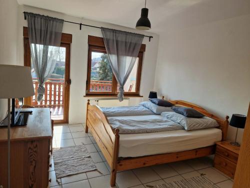 a bedroom with a bed and two windows at Réhelyi in Szigliget