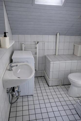 a white bathroom with a sink and a toilet at Réhelyi in Szigliget