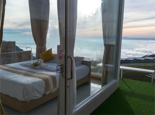 a room with a bed and a window with a view at ชาเลต์ ภูทับเบิก in Ban Maeo Thap Boek