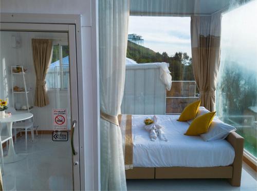a bedroom with a bed and a balcony with a table at ชาเลต์ ภูทับเบิก in Ban Maeo Thap Boek