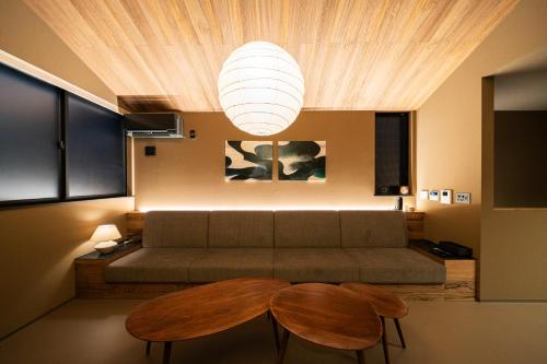 a living room with a couch and two tables at Mon Hotel HAKATA in Fukuoka