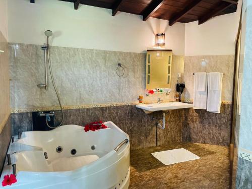 a bathroom with a bath tub and a sink at Hotel Kamrel Sigiriya in Sigiriya