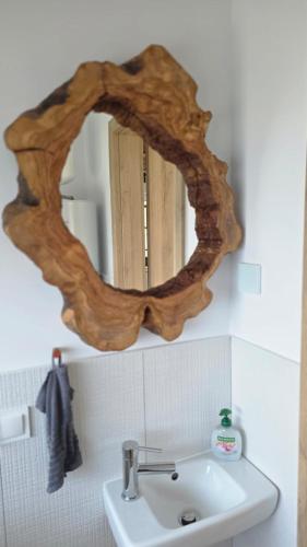 a mirror with a wooden frame above a sink at Dom nad Zbrzycą MODRY in Swornegacie