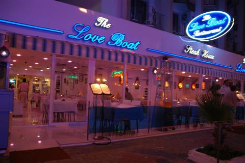 a restaurant with a sign that says the love boat at Devamli Hotel in Marmaris