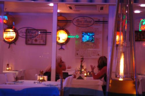 two people sitting at a table in a restaurant at Devamli Hotel in Marmaris
