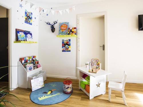 a childs room with a table and a rug at Aparthotel Adagio Access Strasbourg Illkirch in Illkirch-Graffenstaden