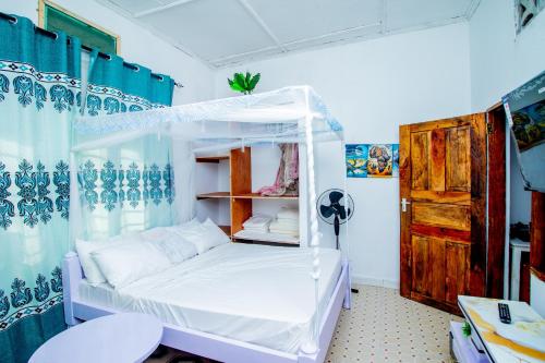 a bedroom with a bed with a canopy at Avana Studio Watamu in Watamu