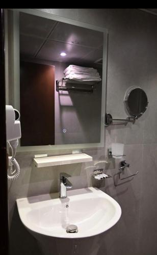 a bathroom with a white sink and a mirror at Manazel AlSafiyah Hotel in Medina