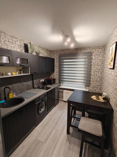a kitchen with a sink and a washing machine at Agnes Apartament in Valmiera