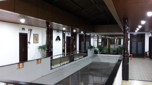 a lobby of a building with a hallway and a lobby at Hotel Mudra Midtown in Kalasa