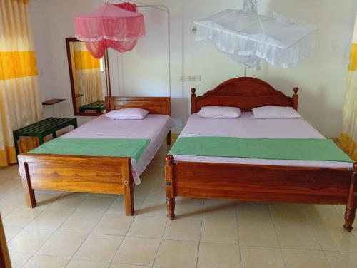 a bedroom with two beds and a mirror at The Nest in Mahiyangana