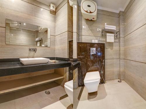 ein Badezimmer mit Waschbecken, Toilette und Spiegel in der Unterkunft Hotel Platinum Grand Near IGI Airport Delhi in Neu-Delhi