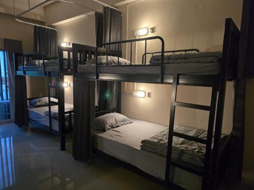 a room with three bunk beds in a hostel at Buddy Hostel in Chiang Rai