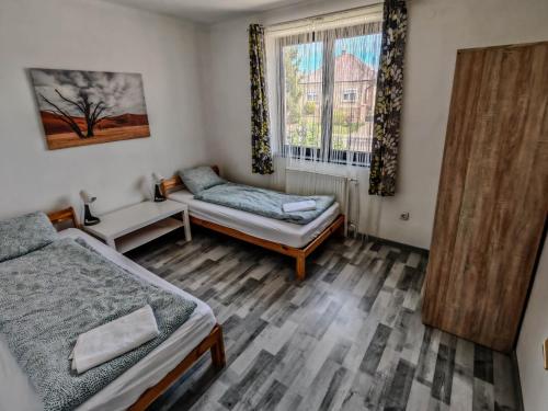 a bedroom with two beds and a window at Artemis Vendégház in Bogács