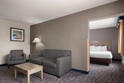 a hotel room with a couch and a bed at Baymont by Wyndham Waukesha in Waukesha