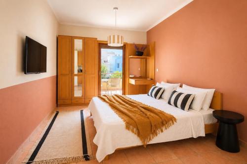 a bedroom with a large bed and a television at Lidra Rooms in Chania