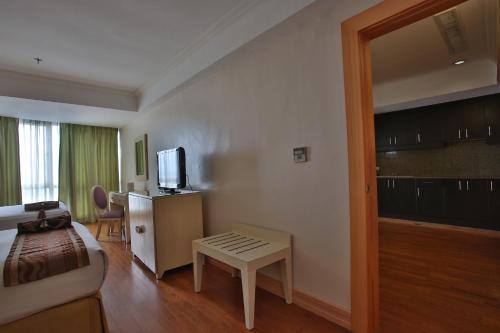 a hotel room with a bed and a tv and a couch at Crown Regency Hotel & Towers in Cebu City