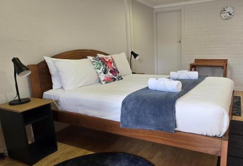 a bedroom with a bed with two pillows on it at Denmark Waterfront Lodge in Denmark