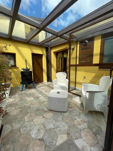 an outdoor patio with white furniture and a glass roof at CAMILLA affitta camere in Nicolosi