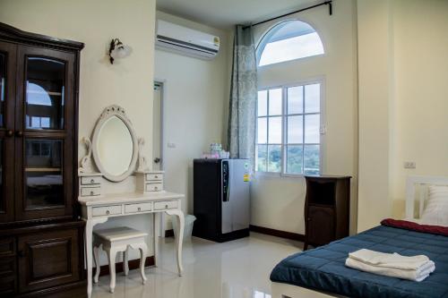 a bedroom with a bed and a mirror and a sink at Plern Pitch Residence in Pak Chong