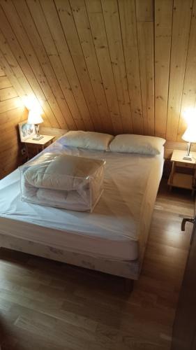 a large bed in a wooden room with two lamps at Chaguimama Snow in Eyne