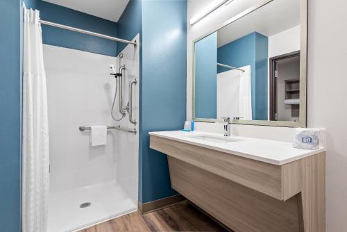 a bathroom with a sink and a shower at WoodSpring Suites Lancaster North in Lancaster