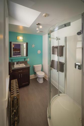 a bathroom with a shower and a toilet and a sink at Cloudside Hotel in Nelson