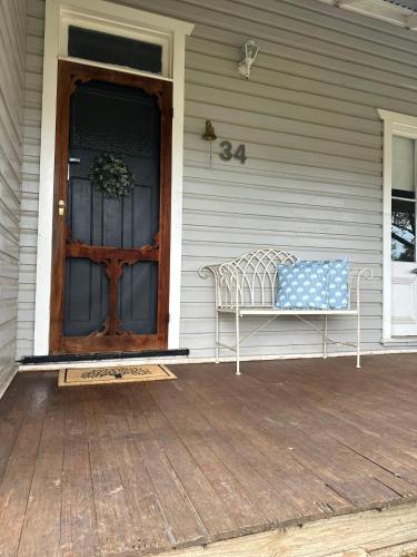 a bench on the front porch of a house at Wattle Cottage in Cootamundra