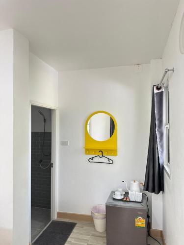 a bathroom with a yellow mirror on the wall at โรงแรมซุนเซนโฮมแอนด์คาเฟ่ in Ban Na Lao
