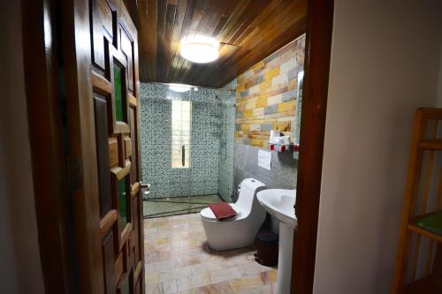 een badkamer met een douche, een toilet en een wastafel bij Khaosok Las Orquideas Resort in Khao Sok