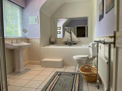 a bathroom with a tub and a toilet and a sink at White House tree view in Drumshanbo